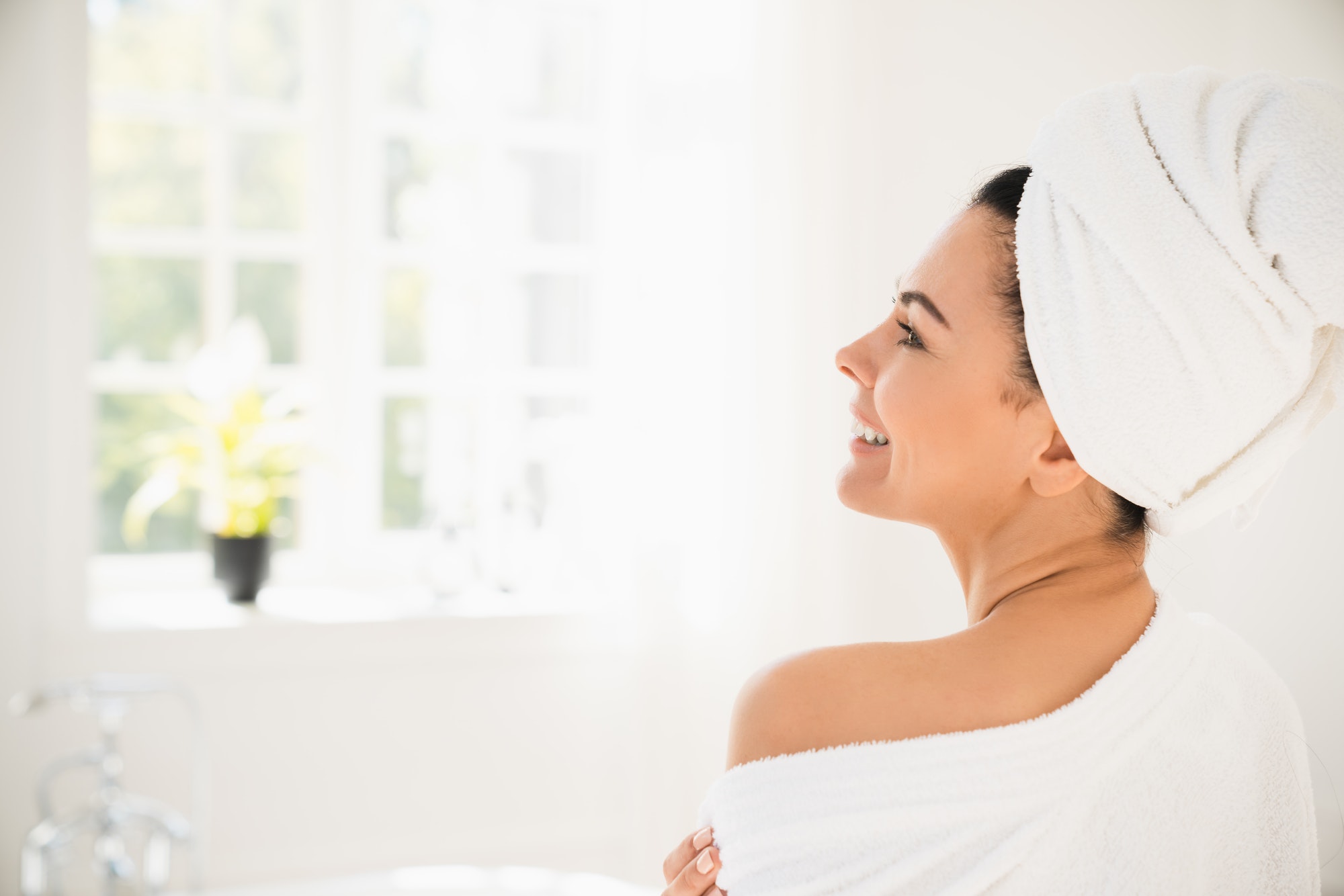 Mature woman in turban and spa bathrobe relaxing after hot shower bath at home resort spa hotel.